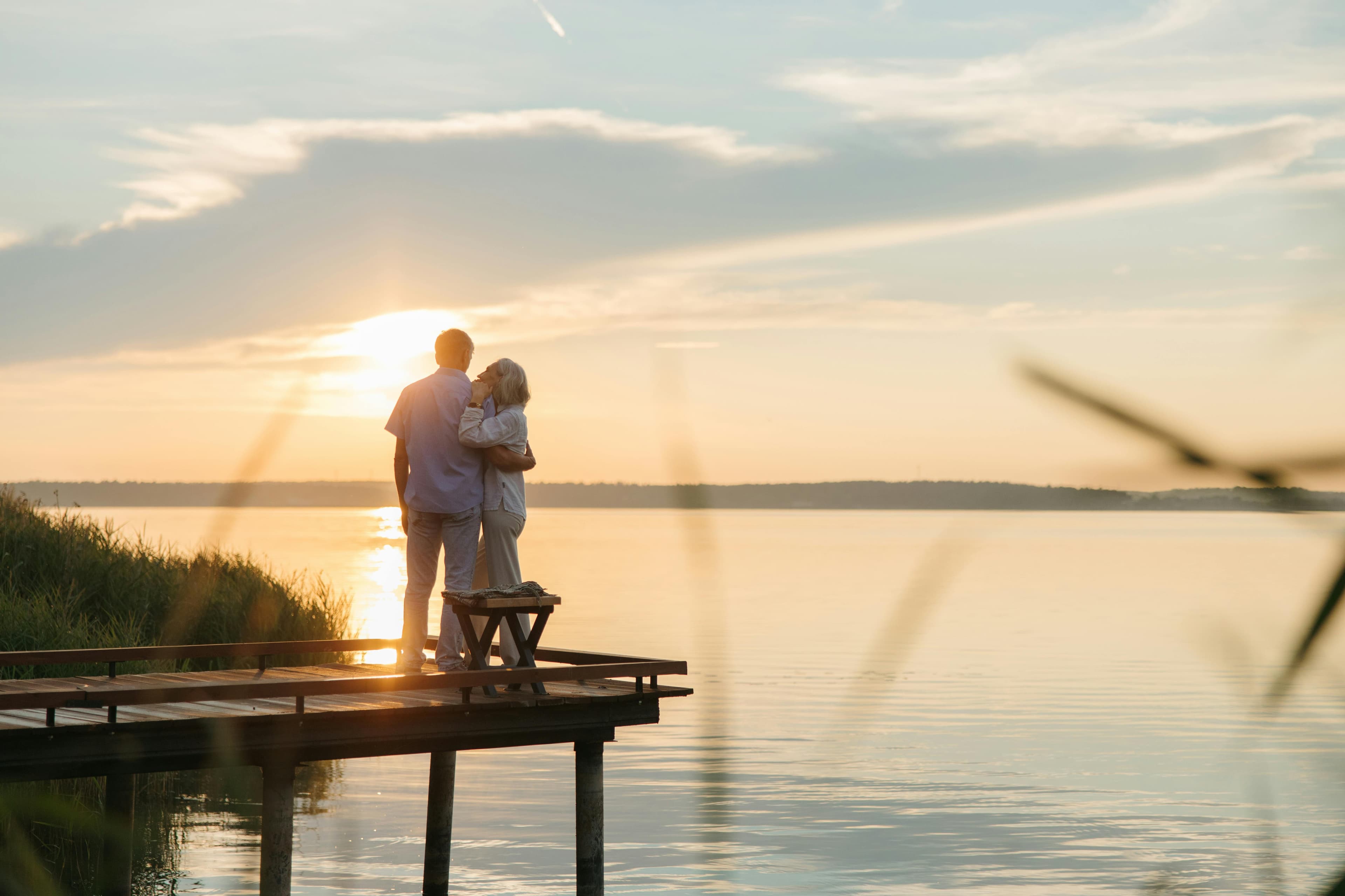 Couple watching the sunrise together near the water.